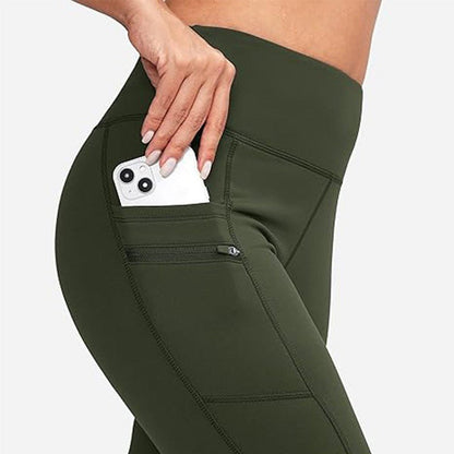 Legging vert ZENTENUE avec poche latérale et compartiment zippé, pensé pour le yoga et les déplacements. Le modèle insère un smartphone dans la poche, illustrant la fonctionnalité et l’élégance du design.